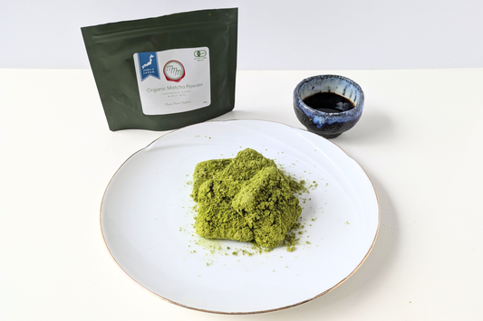 Matcha mochi (Abekawa Mochi) coated in sweet matcha kinako and served with black syrup on a plate